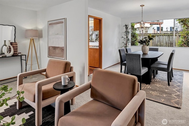 dining room with a chandelier, carpet flooring, and baseboards