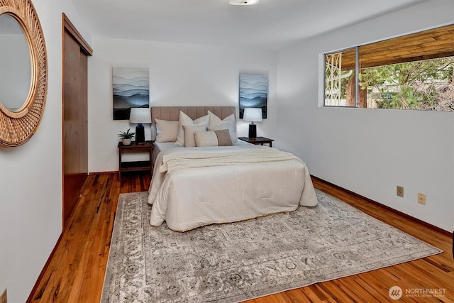 bedroom with baseboards and wood finished floors