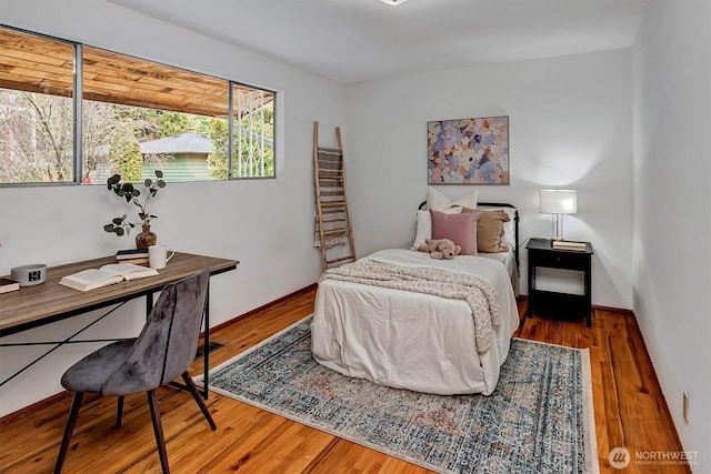 bedroom featuring baseboards and wood finished floors