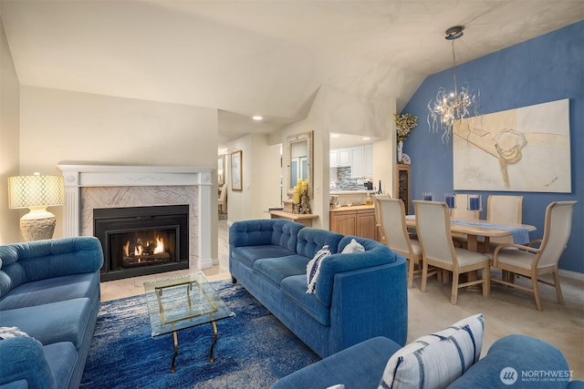 living room with light carpet, a fireplace, baseboards, vaulted ceiling, and an inviting chandelier