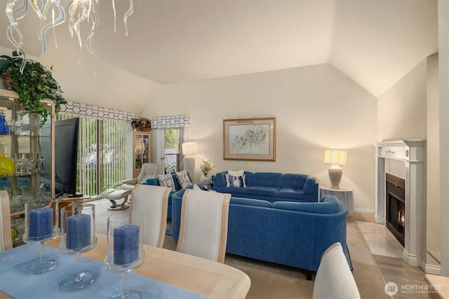 living area featuring lofted ceiling and a fireplace with flush hearth