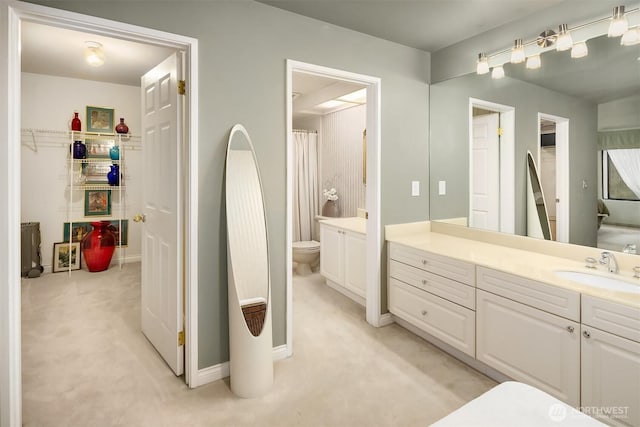 full bathroom featuring vanity, toilet, and a spacious closet