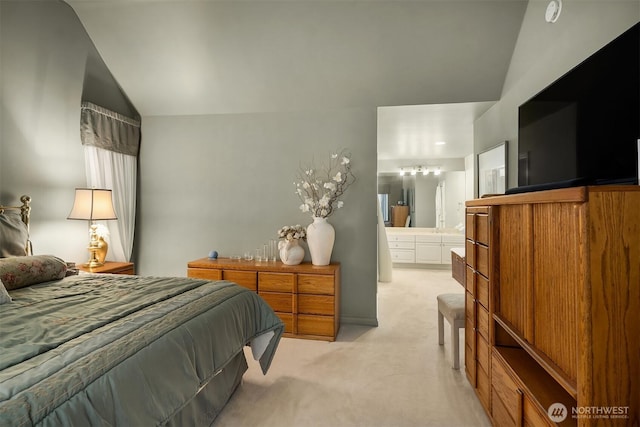 bedroom with vaulted ceiling, connected bathroom, and light colored carpet