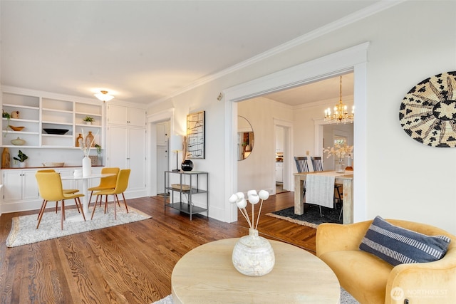 living room featuring dark wood-type flooring, a chandelier, crown molding, and baseboards