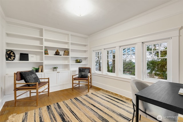 living area featuring light wood finished floors, baseboards, ornamental molding, and a wealth of natural light