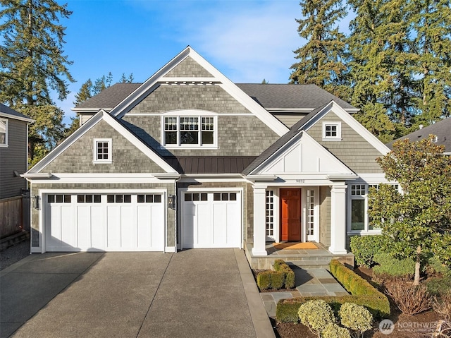 view of front facade featuring a garage, roof with shingles, driveway, and board and batten siding