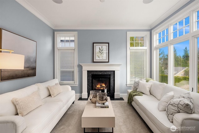 carpeted living room featuring baseboards, a premium fireplace, and crown molding