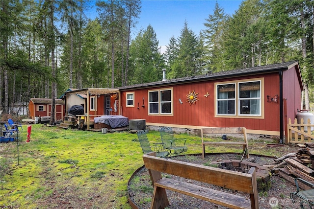 manufactured / mobile home with a garden, central AC unit, an outbuilding, a storage unit, and a front yard