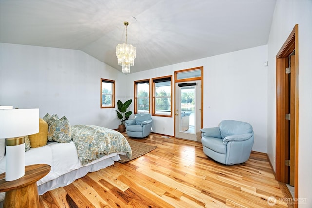 bedroom with vaulted ceiling, access to outside, a notable chandelier, and light wood-style floors