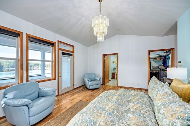 living room featuring lofted ceiling, light wood-style flooring, and a chandelier