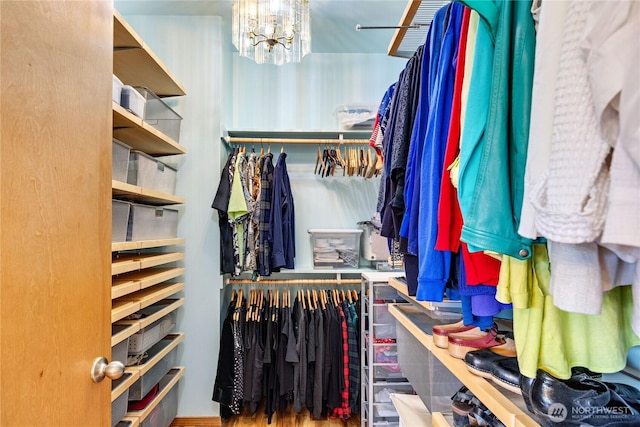 walk in closet featuring a chandelier