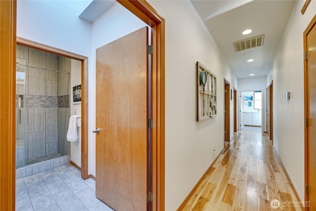 corridor with light wood-type flooring, visible vents, baseboards, and recessed lighting