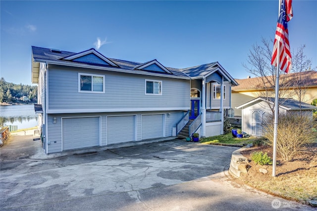 view of front of home with a garage, an outbuilding, and a water view