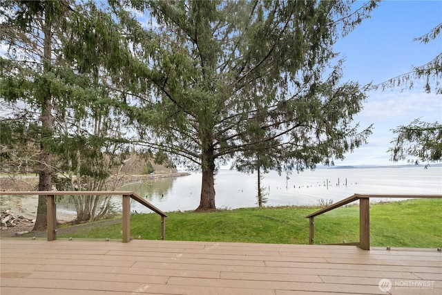 wooden deck with a yard and a water view