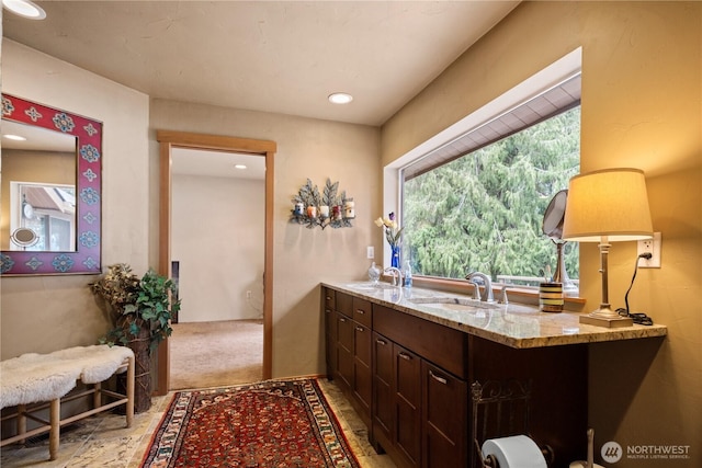 full bath with double vanity, a sink, and recessed lighting