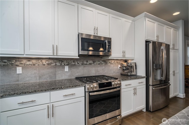 kitchen featuring stainless steel appliances, dark stone countertops, dark wood finished floors, and white cabinets