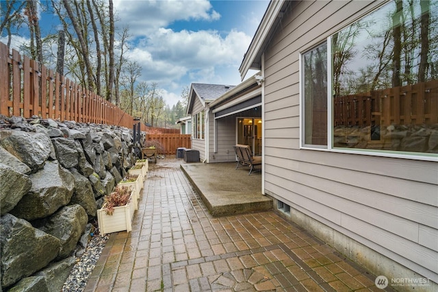 view of side of home with a fenced backyard and a patio