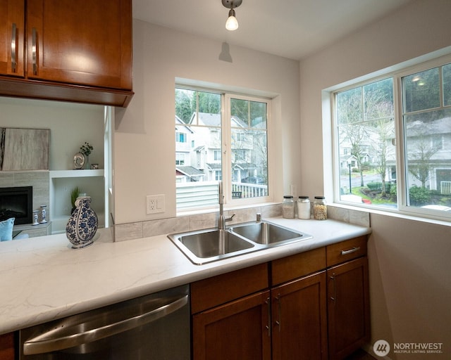 kitchen featuring plenty of natural light, light countertops, dishwasher, and a sink