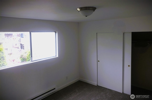 unfurnished bedroom featuring dark colored carpet and a baseboard radiator