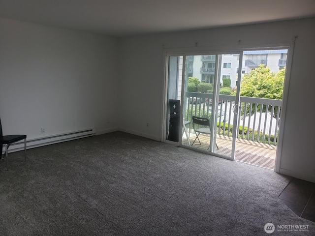 spare room featuring plenty of natural light, a baseboard heating unit, and dark carpet