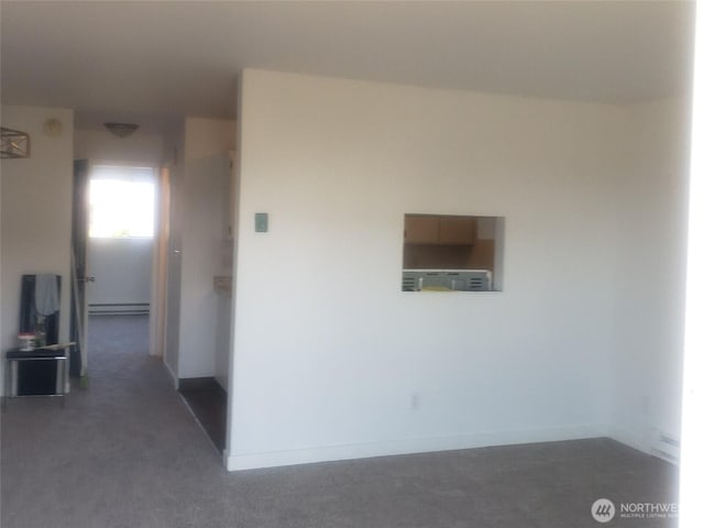 corridor with a baseboard radiator and baseboards