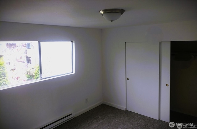 unfurnished bedroom featuring a baseboard radiator and dark carpet