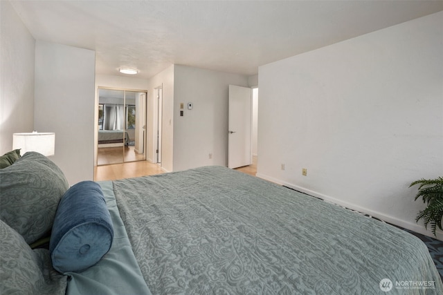 bedroom with light wood finished floors and baseboards