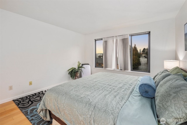 bedroom featuring baseboards and wood finished floors