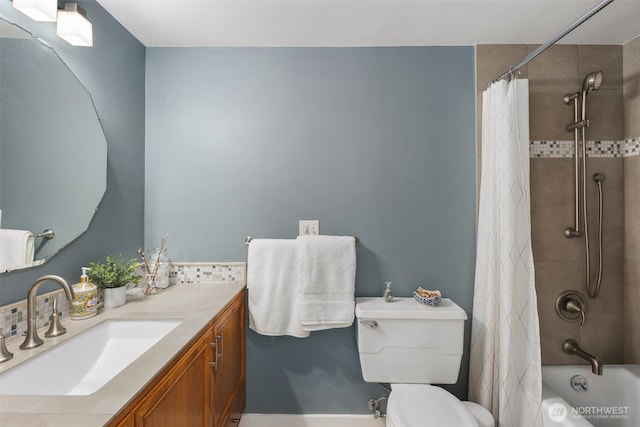 bathroom with toilet, shower / bath combo with shower curtain, and vanity