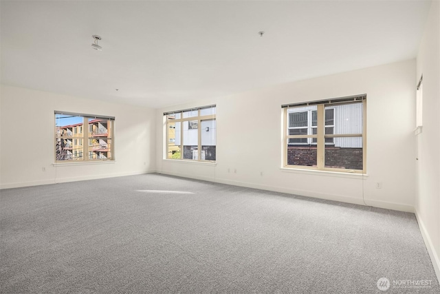 empty room featuring carpet flooring and baseboards