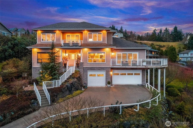 prairie-style home featuring a garage, a balcony, stone siding, and stairway