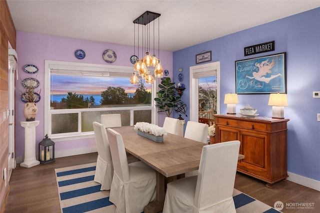 dining room featuring an inviting chandelier, baseboards, and wood finished floors