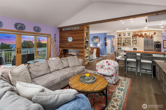 living area featuring lofted ceiling, french doors, dark wood-type flooring, and a multi sided fireplace