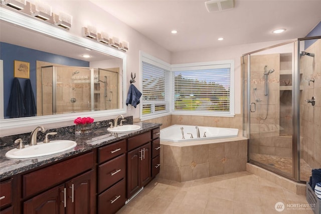 bathroom with a stall shower and a sink