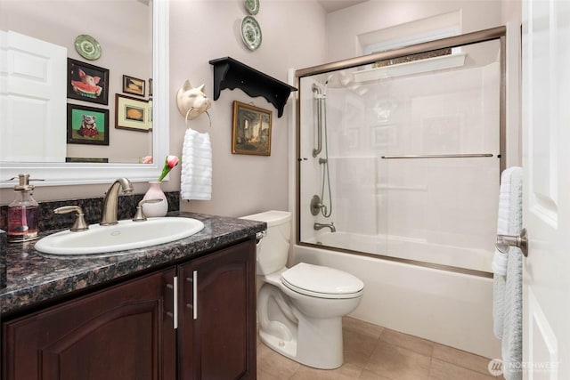 full bath featuring toilet, tile patterned flooring, bath / shower combo with glass door, and vanity