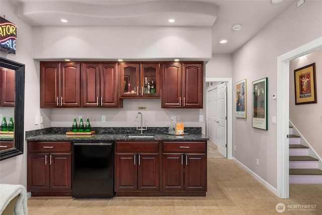 kitchen with dark stone counters, dishwasher, glass insert cabinets, a sink, and recessed lighting