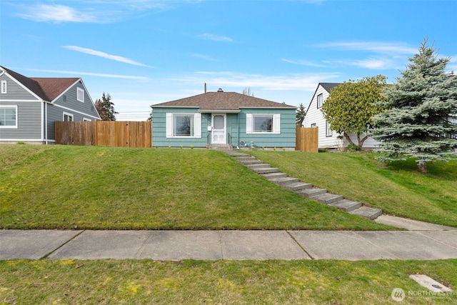 bungalow-style home with a front lawn and fence