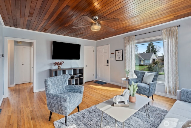 living area with wood finished floors, baseboards, and ceiling fan