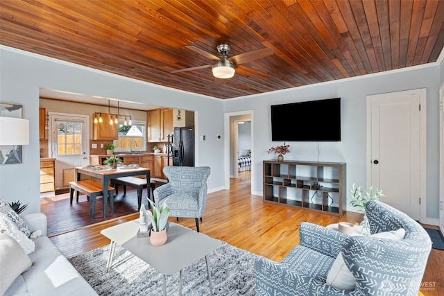 living room featuring wooden ceiling, light wood-type flooring, crown molding, and ceiling fan