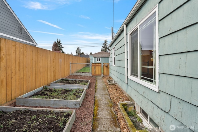 view of yard featuring a gate, a vegetable garden, and fence