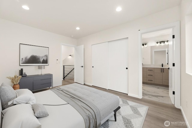 bedroom with light wood-style flooring, a closet, and recessed lighting