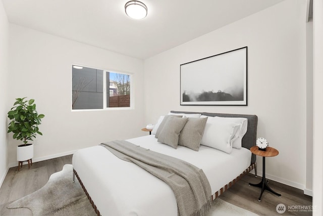 bedroom with baseboards and wood finished floors