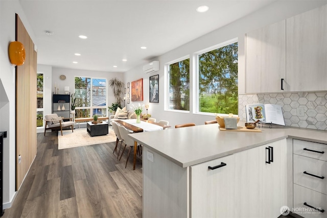 kitchen with modern cabinets, open floor plan, light countertops, and a wall mounted AC