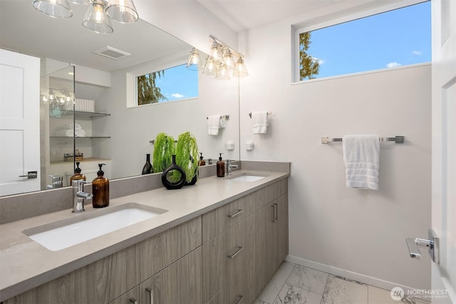 full bathroom with marble finish floor, baseboards, visible vents, and a sink