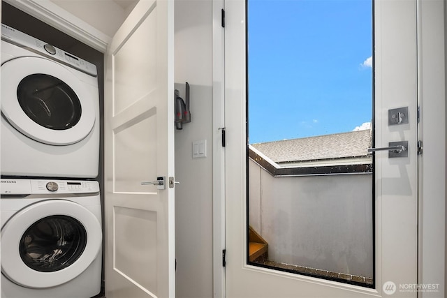 laundry room with stacked washer / drying machine and laundry area