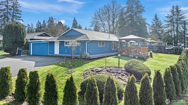 single story home featuring driveway, a garage, a gazebo, a wooden deck, and a front yard