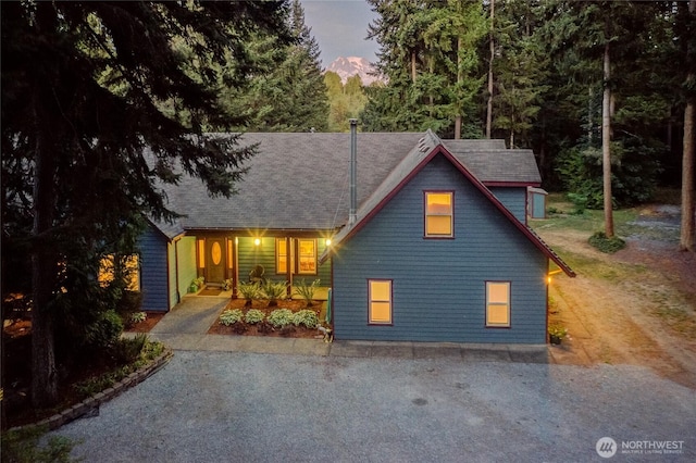 view of front facade featuring gravel driveway and covered porch