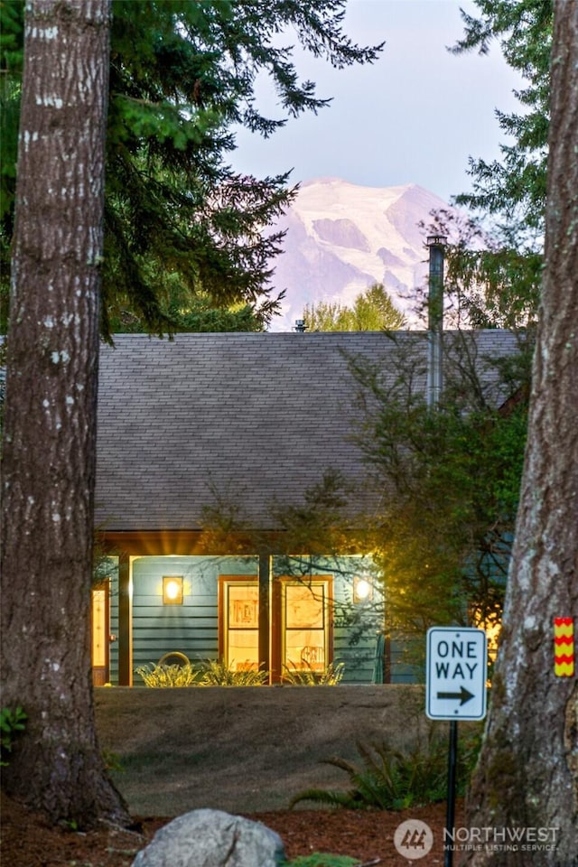 view of front facade with a shingled roof and a mountain view