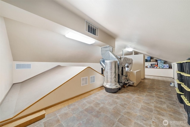 additional living space featuring lofted ceiling and visible vents