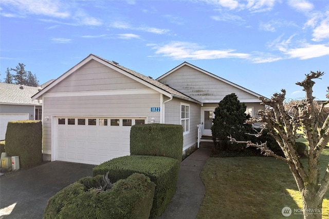 ranch-style home with aphalt driveway and an attached garage